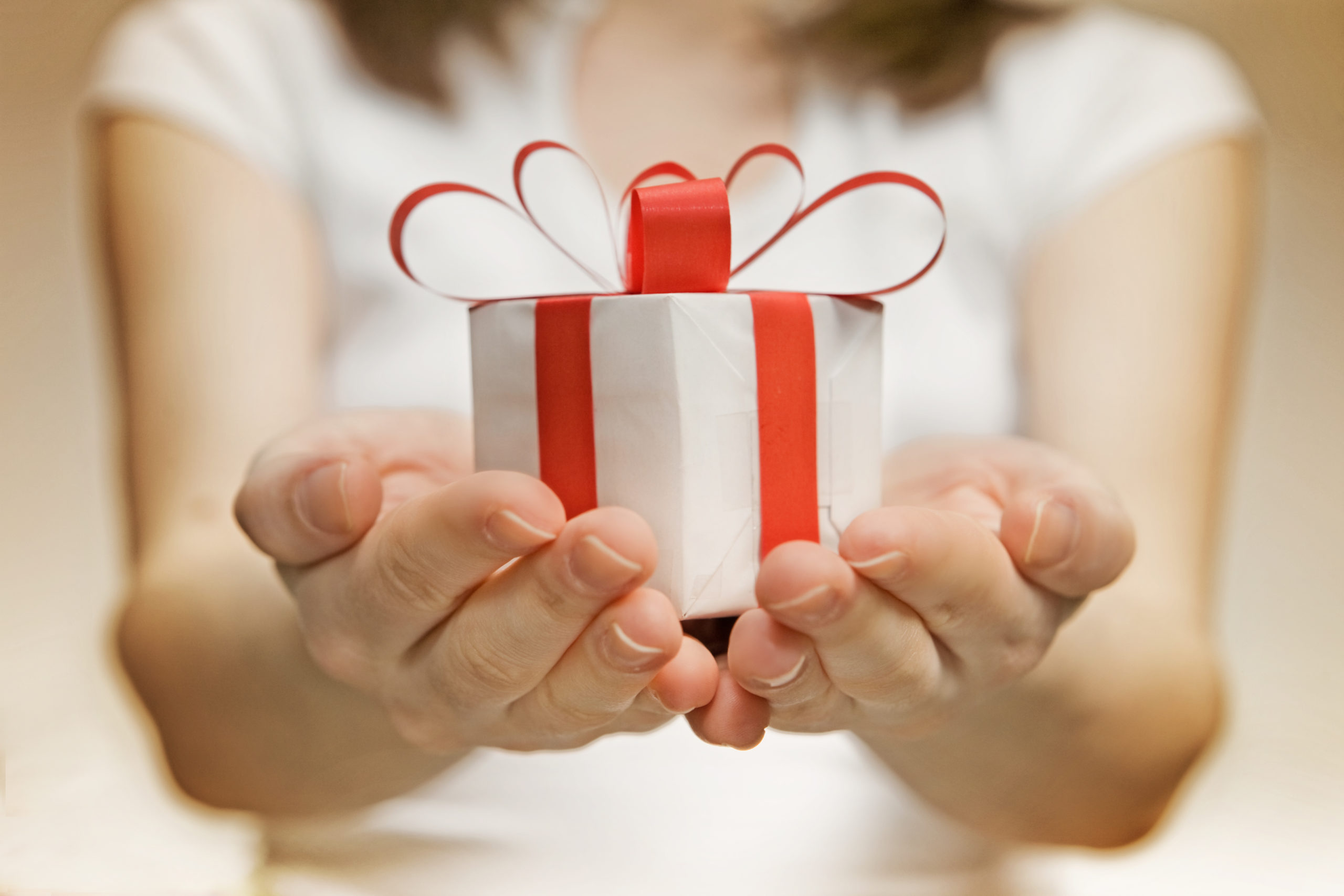 Преподносит приятные сюрпризы. Дарим подарки. Подарок в руках. Дарение подарков. Вручение подарка.