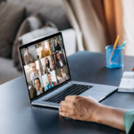 A laptop open with a virtual meeting on display.