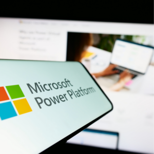 Mobile phone with logo of software application Microsoft Power Platform on screen in front of website.