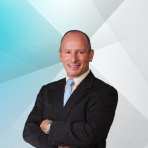 Russell Goldberg , smiling in a professional headshot with a blue and white background.