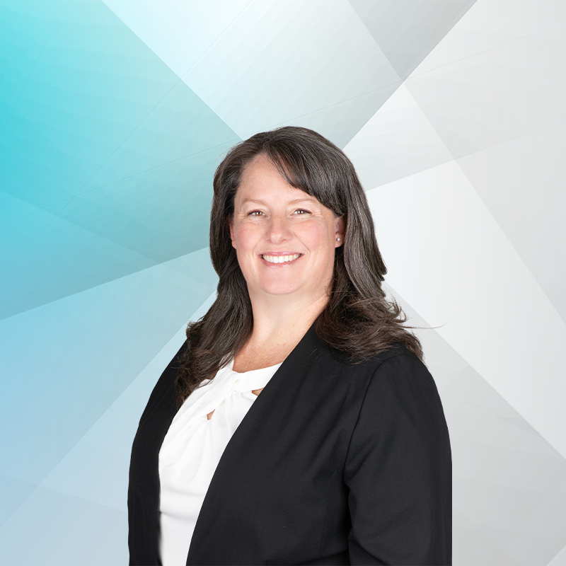 Wendy Heiss, Partner, smiling in a professional headshot. She is wearing a black blazer with a white blouse. The background is different shades of blue.